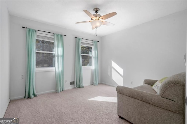 living area featuring light colored carpet and ceiling fan