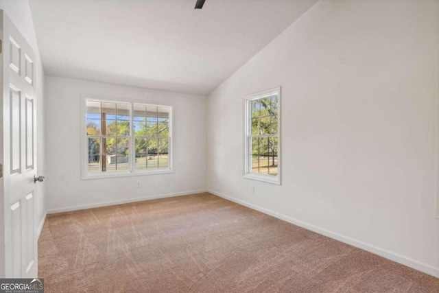 carpeted empty room with lofted ceiling