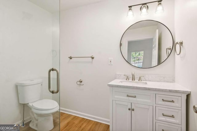 bathroom featuring vanity, hardwood / wood-style flooring, and toilet