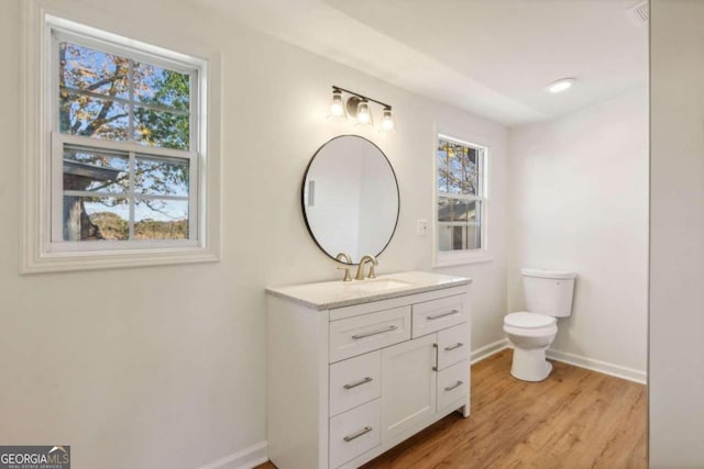 bathroom featuring hardwood / wood-style floors, vanity, toilet, and plenty of natural light