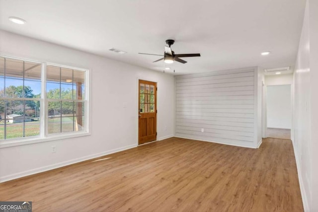 empty room with ceiling fan, light hardwood / wood-style floors, and a wealth of natural light