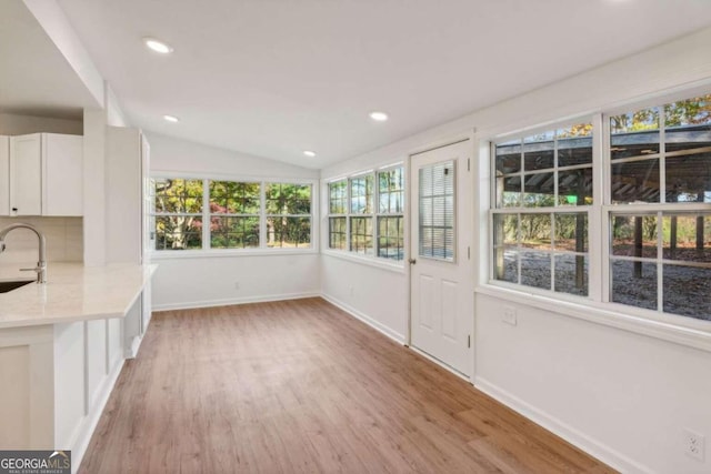 unfurnished sunroom with sink and vaulted ceiling