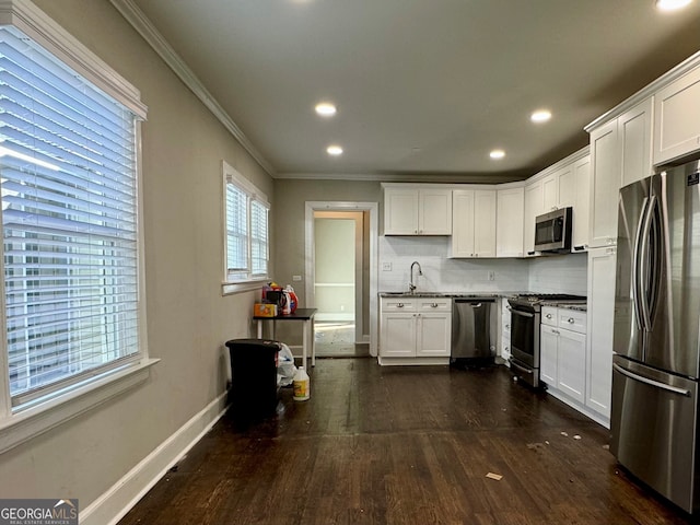 kitchen with dark wood-type flooring, white cabinets, crown molding, tasteful backsplash, and stainless steel appliances