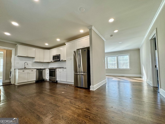 kitchen featuring appliances with stainless steel finishes, dark hardwood / wood-style floors, white cabinetry, and crown molding