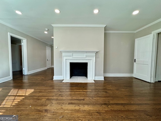 unfurnished living room featuring dark hardwood / wood-style floors, ornamental molding, and a brick fireplace