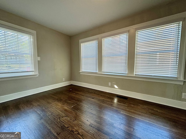 unfurnished room with dark wood-type flooring