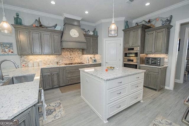 kitchen with ornamental molding, custom exhaust hood, double oven, sink, and decorative light fixtures