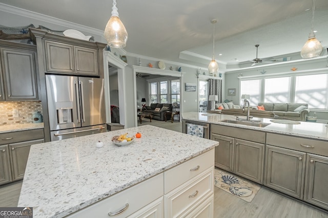 kitchen with sink, ceiling fan, decorative backsplash, ornamental molding, and appliances with stainless steel finishes