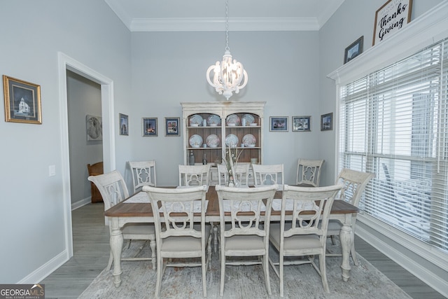 dining space featuring hardwood / wood-style floors, an inviting chandelier, and ornamental molding