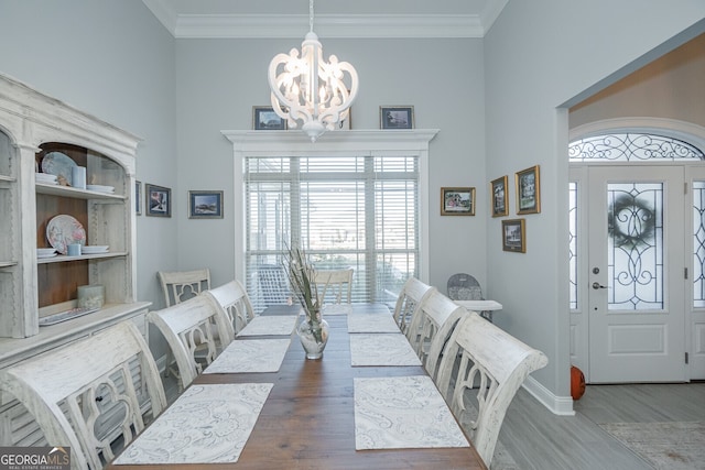 dining area featuring dark hardwood / wood-style flooring, ornamental molding, and an inviting chandelier