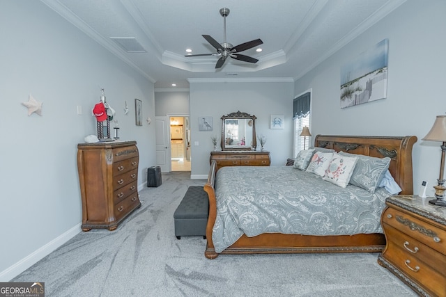 carpeted bedroom featuring a raised ceiling, ceiling fan, crown molding, and ensuite bathroom