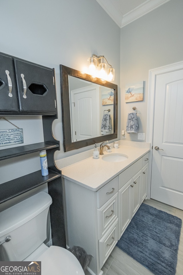 bathroom with vanity, hardwood / wood-style flooring, toilet, and ornamental molding