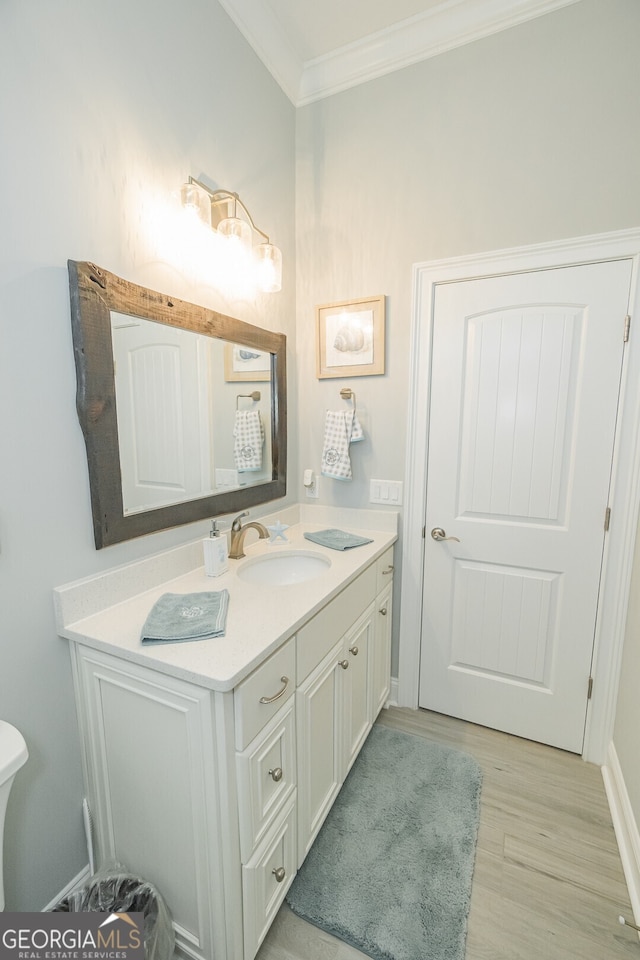 bathroom featuring hardwood / wood-style flooring, vanity, and ornamental molding