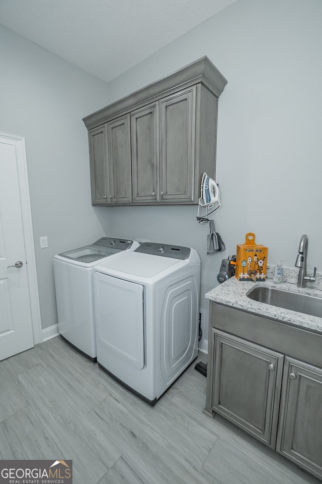 laundry area featuring cabinets, independent washer and dryer, and sink