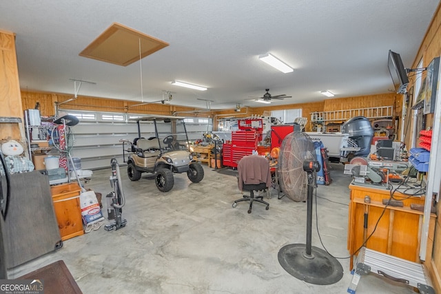 garage with ceiling fan and wooden walls