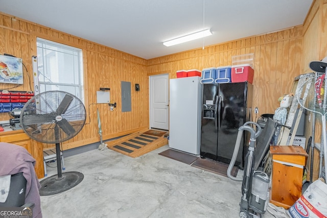 misc room featuring electric panel, wood walls, and concrete floors