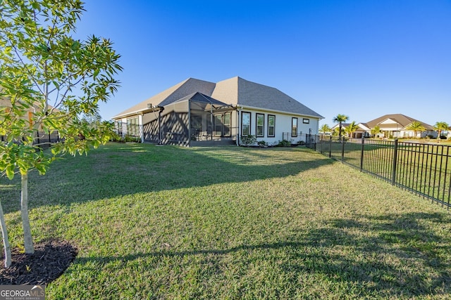 rear view of property with a lawn and a sunroom