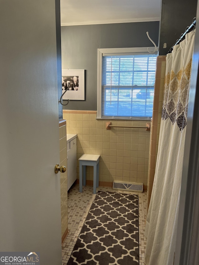 bathroom featuring crown molding, tile walls, and curtained shower