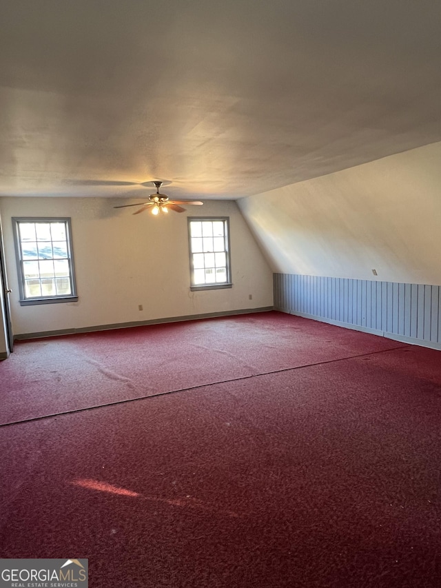 additional living space with ceiling fan, carpet, and vaulted ceiling