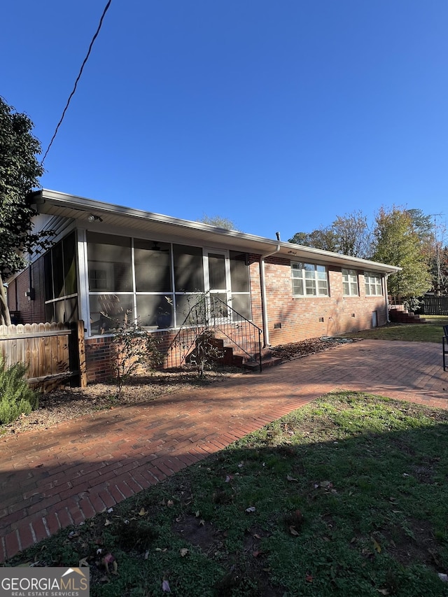 view of front of property featuring a sunroom and a front lawn