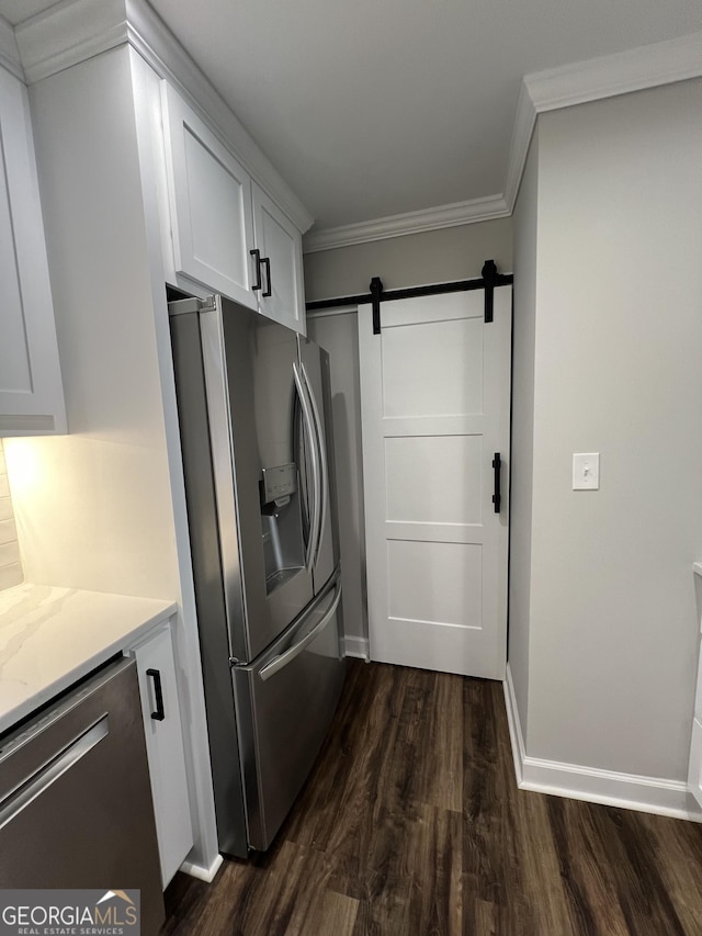 kitchen with dark hardwood / wood-style flooring, stainless steel appliances, crown molding, a barn door, and white cabinetry