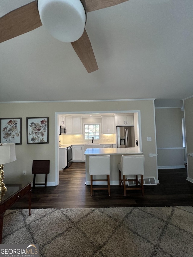 interior space featuring dark hardwood / wood-style flooring, vaulted ceiling, and sink