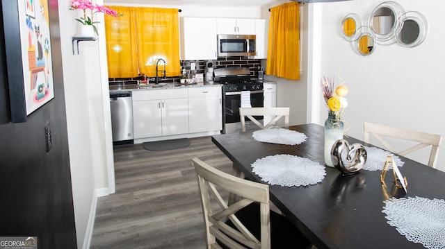 kitchen featuring white cabinets, sink, decorative backsplash, dark hardwood / wood-style floors, and stainless steel appliances