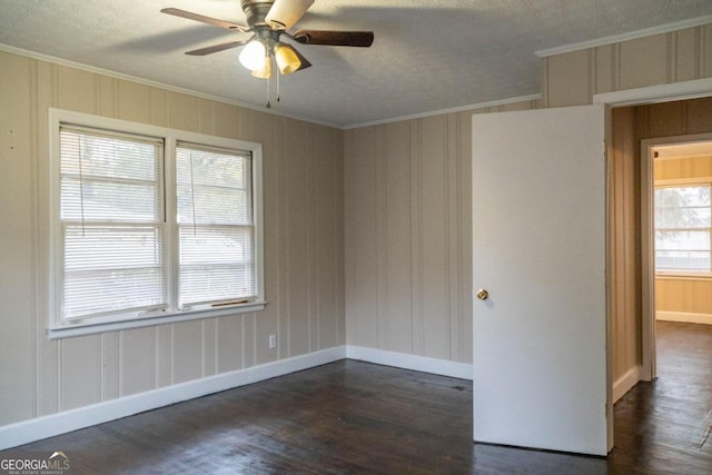 spare room featuring a textured ceiling, ceiling fan, dark hardwood / wood-style flooring, and crown molding