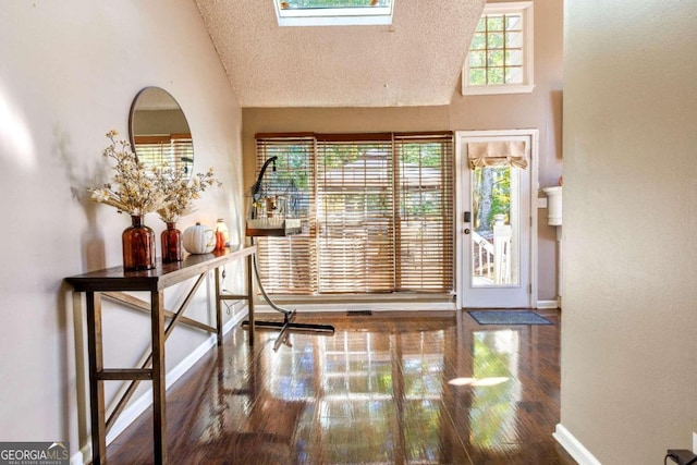 foyer entrance with hardwood / wood-style floors, a textured ceiling, and high vaulted ceiling