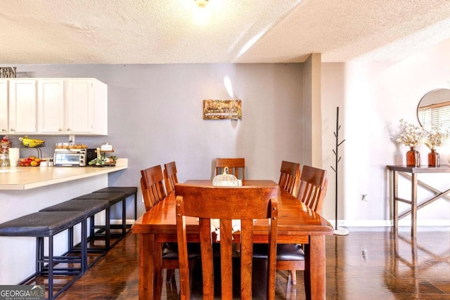 dining room featuring a textured ceiling and dark hardwood / wood-style flooring