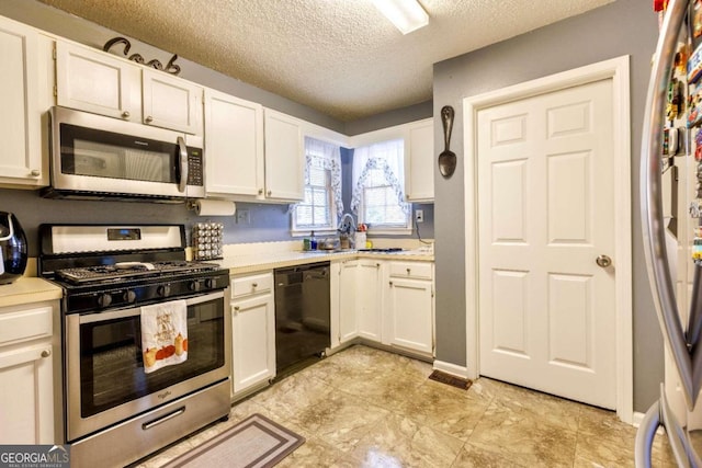 kitchen featuring white cabinets, appliances with stainless steel finishes, a textured ceiling, and sink