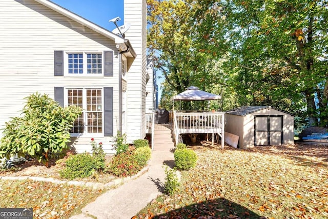 view of home's exterior with a storage shed and a wooden deck