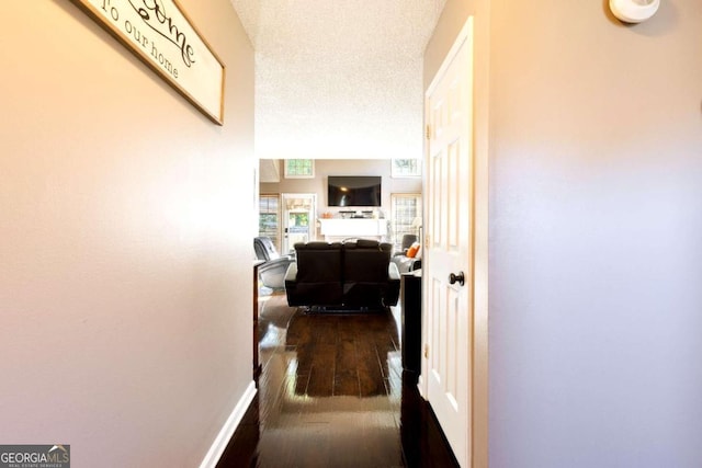 hallway featuring a textured ceiling and dark wood-type flooring