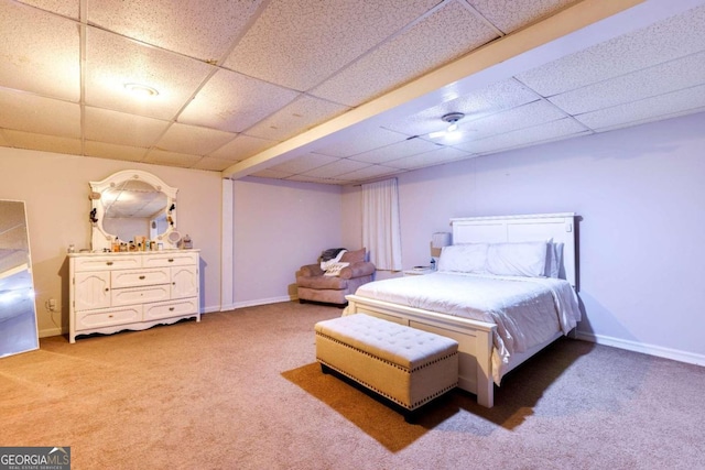 carpeted bedroom featuring a drop ceiling