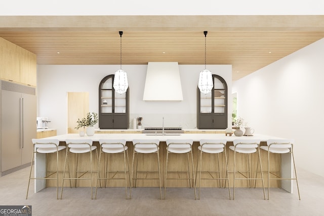 kitchen featuring paneled refrigerator, range hood, hanging light fixtures, and wood ceiling