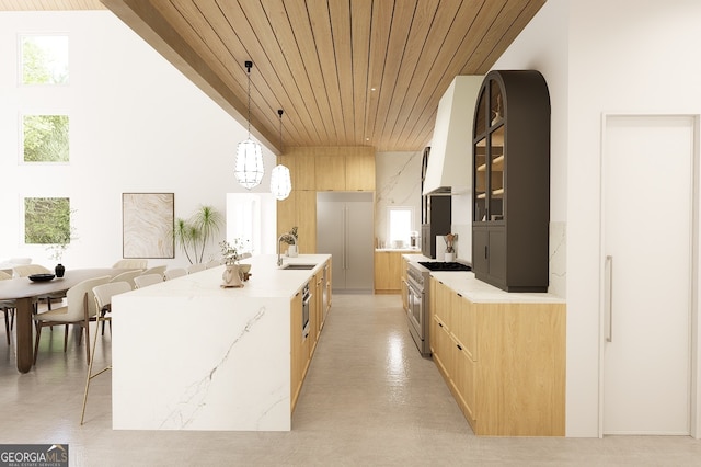 kitchen featuring hanging light fixtures, wooden ceiling, plenty of natural light, a kitchen island with sink, and high end range