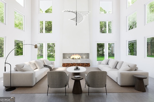 sunroom / solarium featuring a notable chandelier, a fireplace, and french doors