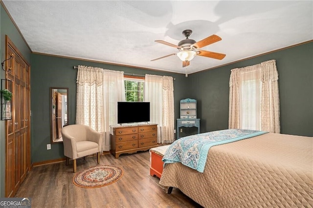 bedroom featuring hardwood / wood-style flooring, ceiling fan, and ornamental molding