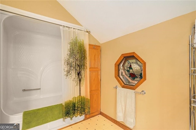 bathroom featuring tile patterned floors, vanity, vaulted ceiling, and toilet