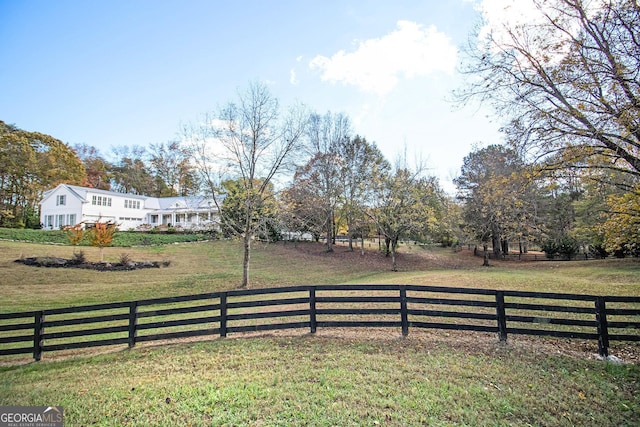 view of yard featuring fence and a rural view