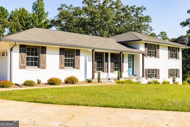 split level home featuring a front yard and a garage