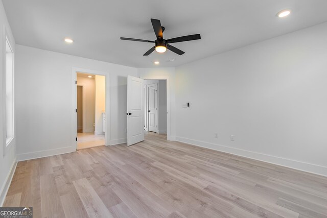 unfurnished bedroom with ceiling fan, ensuite bathroom, and light hardwood / wood-style flooring