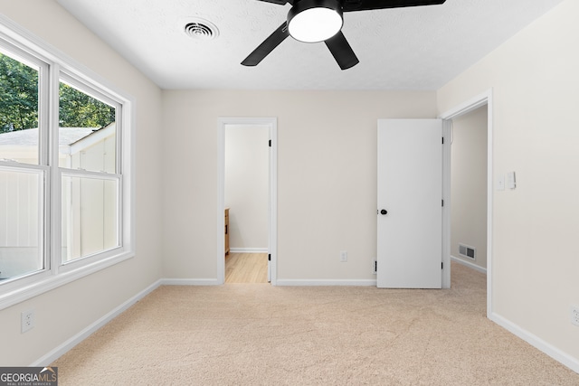 carpeted empty room featuring a textured ceiling and ceiling fan