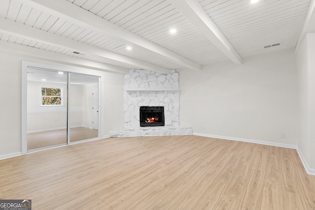 unfurnished living room with a fireplace, light wood-type flooring, beamed ceiling, and wood ceiling