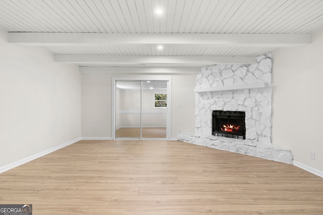 unfurnished living room with beamed ceiling, light wood-type flooring, a fireplace, and wooden ceiling