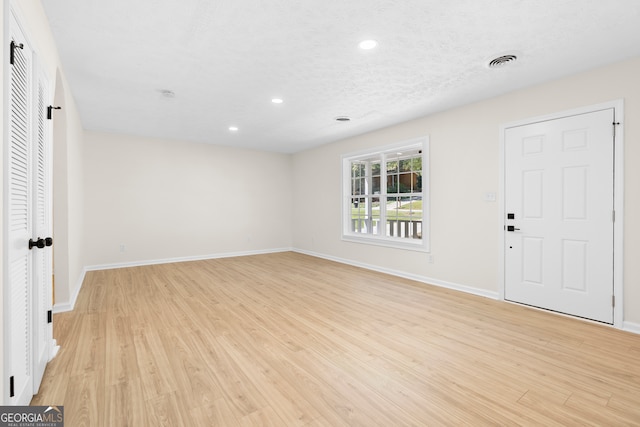 foyer featuring a textured ceiling and light wood-type flooring