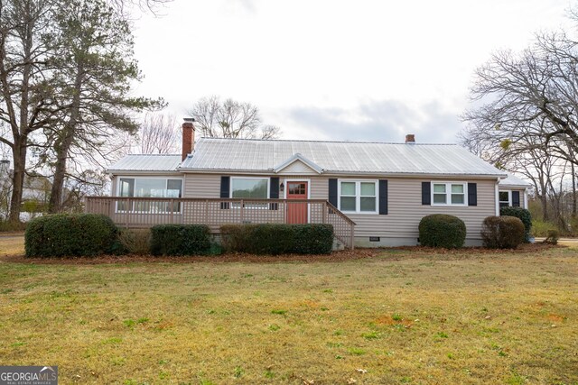 ranch-style home with a deck and a front yard