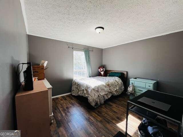 bedroom featuring a textured ceiling and dark wood-type flooring