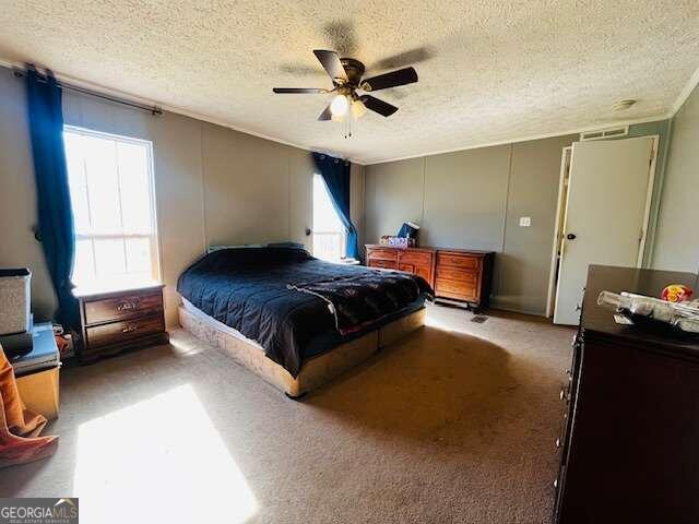 carpeted bedroom featuring a textured ceiling and ceiling fan