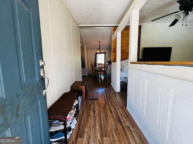 corridor with dark hardwood / wood-style flooring and a textured ceiling